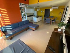 a living room with a blue couch and a kitchen at Departamento con vista al mar in Mazatlán