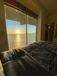a bedroom with a large window looking out at the ocean at Departamento con vista al mar in Mazatlán