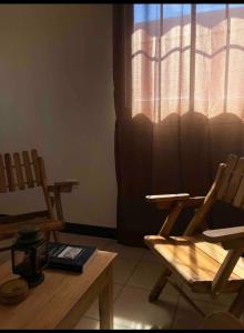 マナグアにあるKami Hostel, Ciudad El Doralの椅子2脚、テーブル、窓が備わる客室です。
