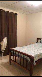 マナグアにあるKami Hostel, Ciudad El Doralのベッドルーム1室(ベッド1台、ファン付)