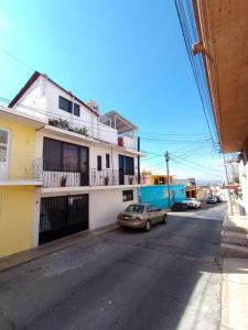 een straat met een auto voor een gebouw bij Posada Lindavista in Tulancingo