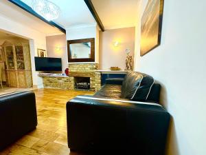 a living room with a couch and a fireplace at Lime Tree House in Heston