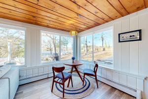 a room with a table and chairs and windows at Harbor House in Lusby