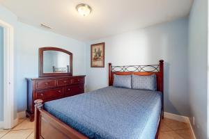 1 dormitorio con cama, tocador y espejo en Pastel Palms, en Lehigh Acres