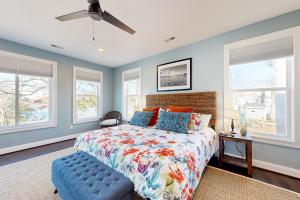 a bedroom with a king sized bed and windows at Harbor House in Lusby