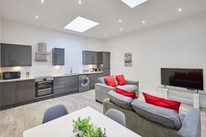 een woonkamer met banken en een keuken bij The Hideaway - Apartment 8 in Sunderland