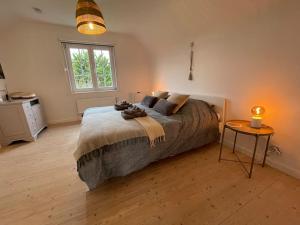a bedroom with a bed and a table and a window at Villa James in Koksijde