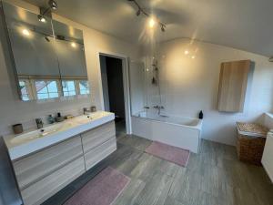 a bathroom with a tub and a sink and a bath tub at Villa James in Koksijde +52 photos