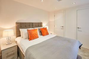 1 dormitorio con 1 cama grande con almohadas de color naranja en The Hideaway - Apartment 8 en Sunderland