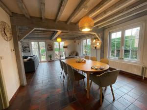 a large living room with a wooden table and chairs at Villa James in Koksijde