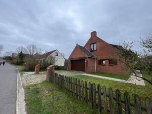 a brick house with a fence next to a street at Villa James in Koksijde