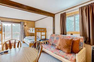 un soggiorno con divano e tavolo di Alpine Horn Lodge at Big Powderhorn Mountain - Unit B a Ironwood