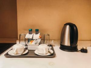 a tray with two cups and a coffee pot on a counter at فندق فيلي Filly Hotel in Hail
