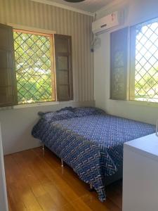 a bedroom with a bed and two windows at Casa de campo Quinta do Floriano in Teutônia