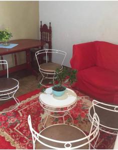 a living room with chairs and a red couch at HOSPEDAJE PRÓCERES DE MAYO in Encarnación