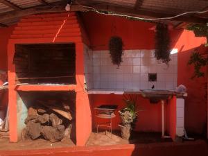 cocina roja con fogones y fregadero en HOSPEDAJE PRÓCERES DE MAYO, en Encarnación