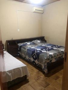 1 dormitorio con 1 cama con edredón azul y blanco en HOSPEDAJE PRÓCERES DE MAYO, en Encarnación