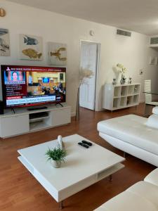 een woonkamer met een grote tv en een witte bank bij Stunning Beach Apartment by Miami Te Espera - HOLLYWOOD 9W in Hollywood