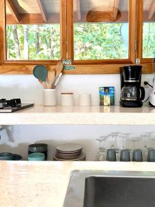 a kitchen counter with a sink and some dishes at Villas Argan - Paradise Gateway in Santa Teresa Beach