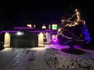 a christmas tree in front of a house with lights at Youth hostel 2 in Calgary