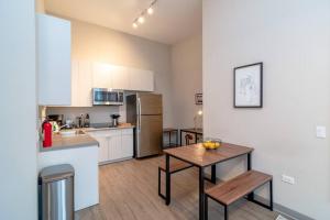 a kitchen with a table and a refrigerator at McCormick Oasis with Balcony, optional Parking, Patio, Gym for up to 6 guests in Chicago