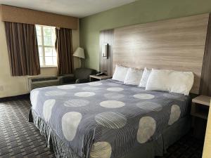 una habitación de hotel con una cama grande y una silla en Day Star Dallas, en Dallas