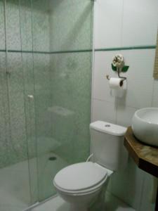 a bathroom with a toilet and a glass shower at Suite Ilhabela in Ilhabela