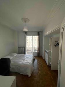 1 dormitorio con cama blanca y ventana en Université Jean Monnet Saint Etienne, en Saint-Étienne