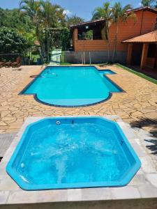 una grande piscina in un cortile con patio in pietra di Chacara Dois Lagos - Mairinque a Mairinque