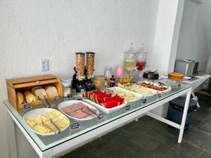 ein Tisch mit einem Buffet mit Speisen drauf in der Unterkunft Kyros Pousada in Maceió