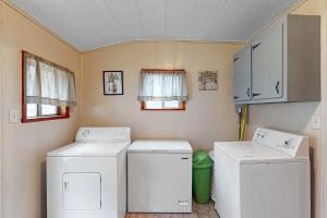 una lavanderia con due lavabi e due lavatrici di Wolf Den Retreat a Swanton