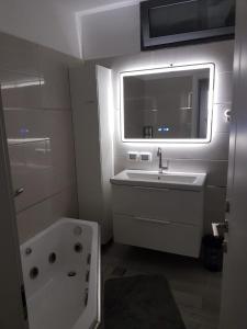 La salle de bains est pourvue d'un lavabo, d'une baignoire et d'une fenêtre. dans l'établissement 4bdrm - 110mr - Dream vacation apartment, à Tibériade