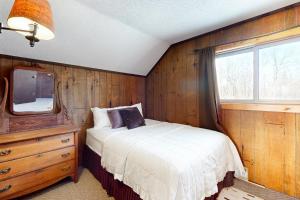a bedroom with a bed and a tv on a wall at Alpine Horn Lodge at Big Powderhorn Mountain - Unit A in Ironwood