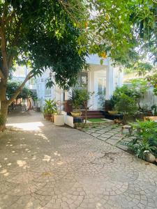 una casa con árboles y plantas delante de ella en Homestay Cô Gái Việt, en Can Tho