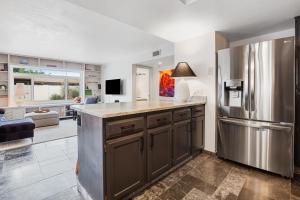 a kitchen with a stainless steel refrigerator and a living room at Hidden Bloom Sanctuary in Litchfield Park +23 photos
