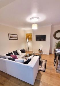 a living room with a white couch and a table at Three Bed House with free on-site parking Sleeps 5 in Warrington