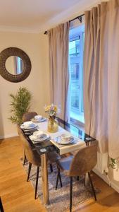 a dining room with a table and chairs and a window at Three Bed House with free on-site parking Sleeps 5 in Warrington
