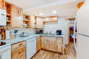 a kitchen with wooden cabinets and white appliances at Alpine Horn Lodge at Big Powderhorn Mountain - Unit C in Ironwood
