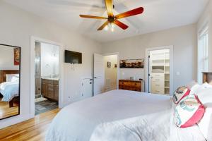 a bedroom with a white bed and a ceiling fan at Artsy City Landing in Asheville