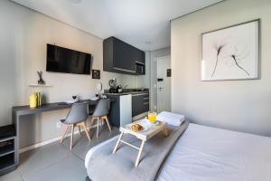 a living room with a table and a kitchen at BA60 Studio Aconchegante Bela Vista São Paulo TPA in São Paulo