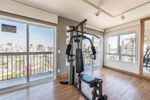 a gym with a treadmill in a room with windows at BA60 Studio Aconchegante Bela Vista São Paulo TPA in São Paulo