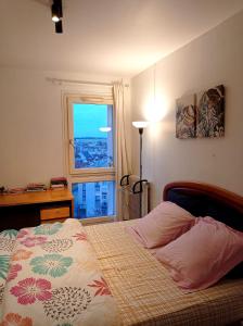 1 dormitorio con cama y ventana con vistas en mariana-basel, en Maisons-Alfort