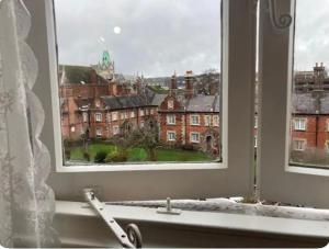 a window with a view of a city through it at Room with a view in Winchester