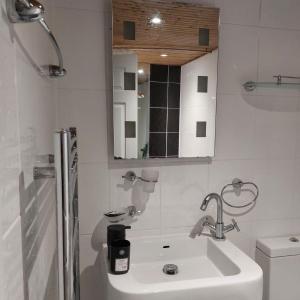 Baño blanco con lavabo y aseo en Three Bed House with free on-site parking Sleeps 5 en Warrington