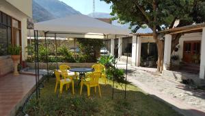 un patio con mesa y sillas debajo de una tienda de campaña en Caraz Dulce Hogar, en Caraz