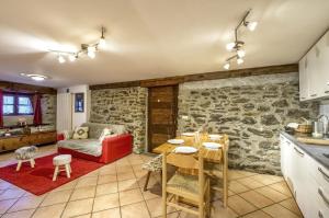 eine Küche und ein Wohnzimmer mit einer Steinmauer in der Unterkunft Maison Chasseur Alpine Design Lodge in Champoluc