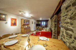 ein Esszimmer mit einem Tisch und einer Steinmauer in der Unterkunft Maison Chasseur Alpine Design Lodge in Champoluc