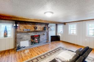 a living room with a fireplace and a couch at Dr. Easterling’s Rustic Lake Home in Hartsville