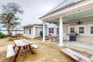 a house with two picnic tables on a patio at Dr. Easterling’s Rustic Lake Home in Hartsville