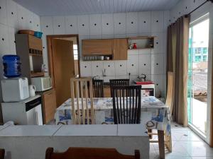 a kitchen with a table and chairs in a room at Casa bom espaço para passar suas férias in Matinhos